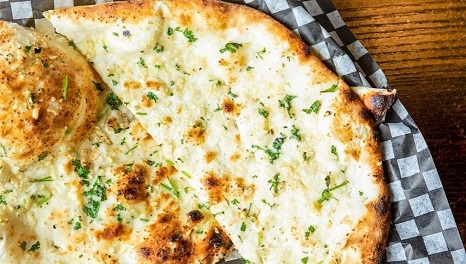 Garlic naan — freshly baked flatbread brushed with garlic butter at Angeethi Flame Indian restaurant Saskatoon